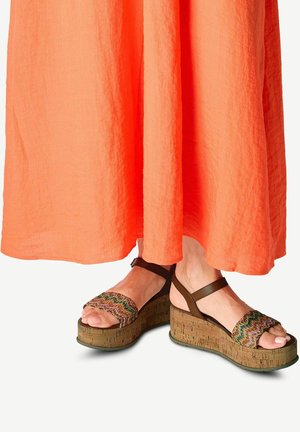 Korkové platformové sandály na klínu, hnědý kotníkový pásek, multicolor tkaný svršek, design s otevřenou špičkou, spárované s oranžovými maxi šaty.