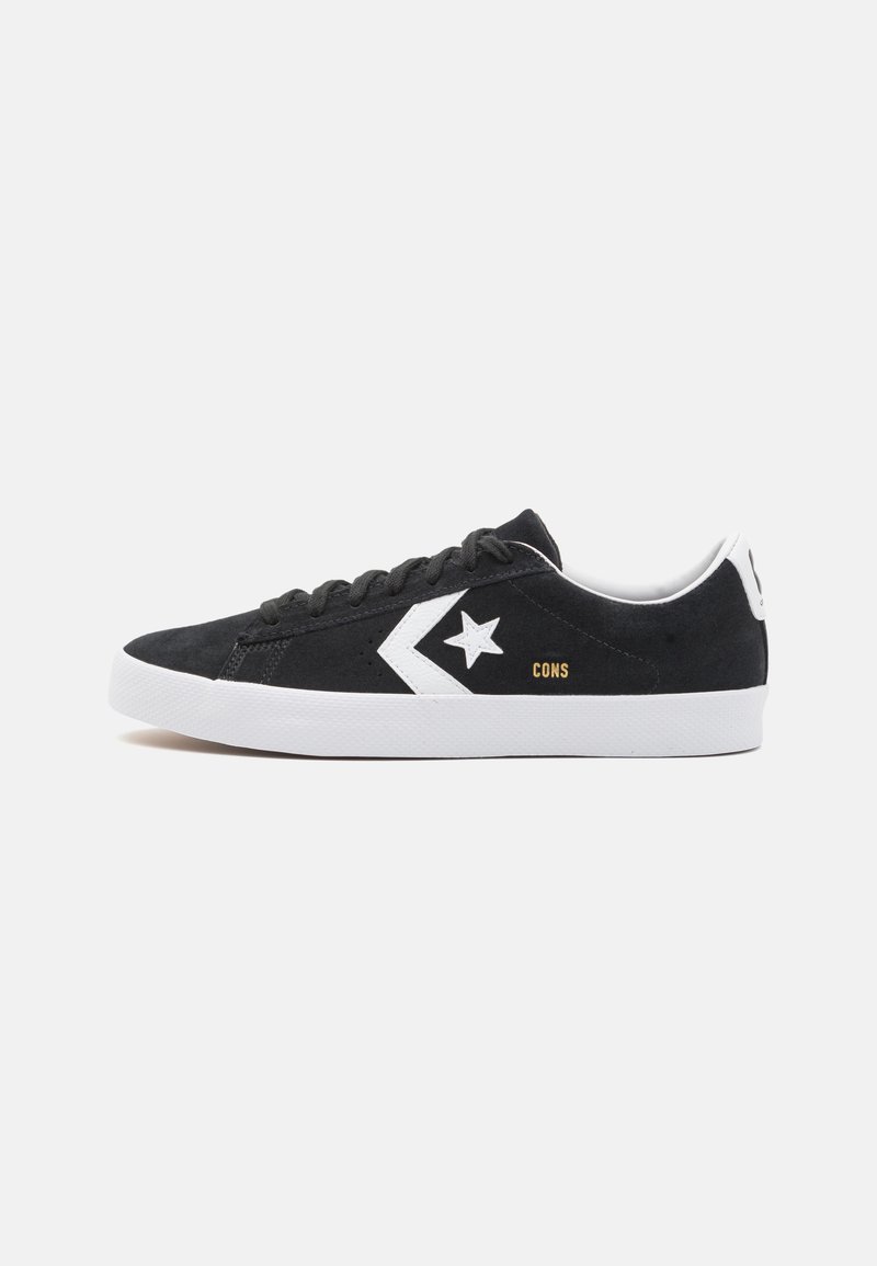 Fekete velúr sneaker fehér kiegészítőkkel, csillag logóval, fűzős előlappal, kerek orral és bordázott gumitalppal.