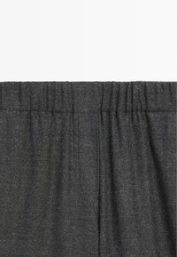 Ciemnoszara tkanina z elastycznym paskiem, z widocznymi zgromadzonymi fałdami i miękką teksturowaną powierzchnią.