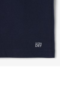 Camiseta ligera azul marino, hecha de algodón, con una etiqueta "ULTRA DRY" en blanco en el dobladillo. Textura suave, mangas cortas y diseño minimalista.