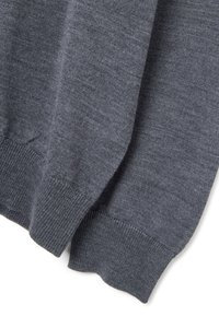 Maglione grigio lavorato a maglia che mostra una texture fine, polsini a coste e un corpo liscio. Nessun motivo visibile o dettagli in metallo.