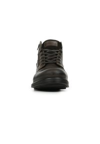 Scarpe in pelle marrone con punta rotonda, design con lacci, superficie testurizzata e suola in gomma a contrasto. Tacco piatto e dettagli di branding minimi.