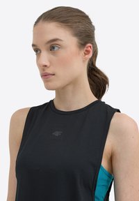 Top deportivo sin mangas negro hecho de una tela texturizada, con un estampado de logo en el pecho y un acento azul claro en el costado.