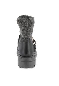 Botín negro de cuero con puño de punto gris, que presenta una suela de goma gruesa y una correa de acento. El puño tiene una apariencia suave y texturizada.