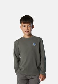 Camiseta de manga larga gris, hecha de una tela suave, con un cuello redondo y un logotipo circular azul en la parte izquierda del pecho.