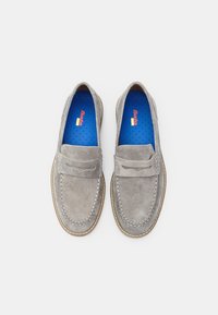 Pantofi slip-on din suede gri cu design de tip loafers, având cusături decorative și o solea albastră căptușită. Talpa are un accent maro.