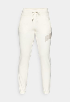 Pantalones de chándal blancos con cintura ajustable mediante cordón, puños elásticos, bolsillos laterales y un logo de "DKNY" en strass en el muslo izquierdo.
