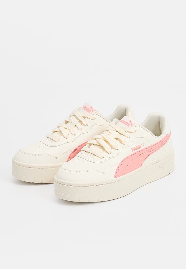 Cremfarbene Sneakers mit einem seitlichen Streifen aus rosa Veloursleder, strukturiertem Lederfinish, flachen Schnürsenkeln und erhabener Gummisohle. PUMA-Logo auf der Zunge.