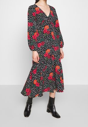 Schwarzes Blumenkleid mit roten und orangefarbenen Blumen, weißen Punkten, V-Ausschnitt, langen Puffärmeln, mehrlagigem Rock, kombiniert mit schwarzen Stiefeletten.