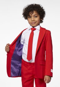 Rode pak met een notch lapel, paarse voering, witte overhemd en bijpassende rode stropdas. Gladde textuur met een getailleerde pasvorm en zichtbare stikseldetails.