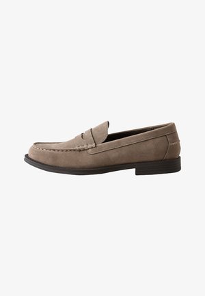 Mocassin penny en daim taupe pour homme avec semelle en caoutchouc noire et couture style mocassin, vue de côté sur fond blanc.