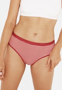 Culotte femme rayée rouge et blanche avec une taille douce arborant le nom de la marque, fabriquée dans un tissu confortable et extensible.