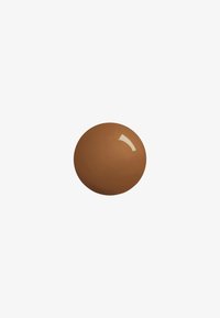 Objet rond marron avec une surface lisse et brillante, représentant une teinte pour le maquillage, sur un fond blanc.