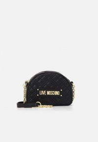 Black quilted half-moon crossbody bag with gold chain strap and Love Moschino gold logo plaque on front.
