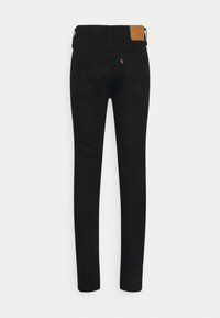 Jeans skinny de mezclilla negra con una textura suave, que cuentan con una etiqueta de cuero en la cinturilla y dos bolsillos traseros.