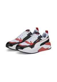 Sneakers neri, bianchi e rossi con un design testurizzato, caratterizzati da pannelli in rete, stringhe e una suola spessa e sagomata. Logo sul lato.