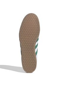 White sneaker sole with a textured gum rubber surface; features green stripes along the side and a contoured shape for grip.