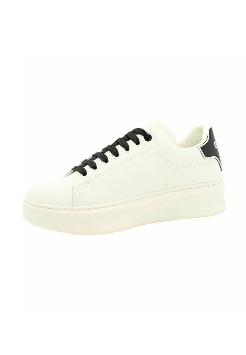 Sneaker bianco in pelle con lacci neri, punta arrotondata e suola spessa. Presenta un accento nero vicino al tallone e dettagli di cucitura sottili.