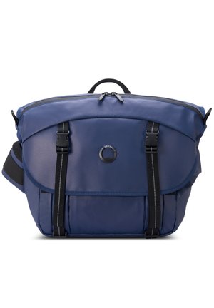 Zaino blu realizzato in tessuto resistente, presenta una forma arrotondata, chiusura con zip, spallacci regolabili e doppie fibbie frontali.