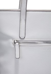 Hvid læder tote bag med en struktureret overflade, der har lange håndtag og en frontlomme med lynlås samt metalhardware detaljer.
