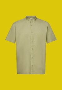 Chemise vert clair à manches courtes avec col mandarin et fermeture à boutons sur le devant, présentée sur un fond jaune.