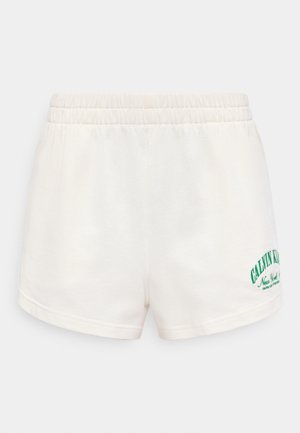 Hvide shorts med elastik i taljen, opviklede kanter og grøn "Calvin Klein New York" tekstlogo på venstre underben.
