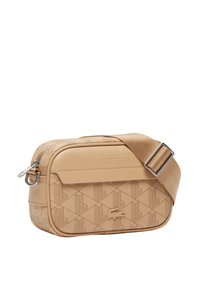 Μπεζ συνθετική τσάντα χιαστί με γεωμετρικό ανάγλυφο μοτίβο, ρυθμιζόμενο λουρί, κλείσιμο με φερμουάρ και λογότυπο στο μπροστινό μέρος.