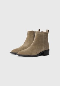Botas de ante hasta el tobillo en verde tierra, con punta afilada, cremallera lateral y un bajo tacón cuadrado negro. Textura suave con un mínimo de detalles.