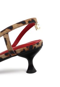Sandały na wysokim obcasie w wzór panterki z czerwonym wnętrzem, czarną teksturowaną podeszwą, cienkimi paskami i złotym akcentem na pasku.