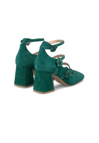 Scarpe con tacco alto in suede teal con tacco a blocco quadrato, caratterizzate da tre fasce decorative con dettagli in gioiello e punte appuntite.