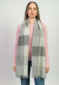 Scarf grigio e bianco a quadri con bordi frangiati, realizzato in un materiale morbido. Indossato sopra un maglione rosa chiaro, pende in un design diritto.