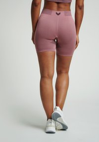 Pantaloni sportivi rosa con vita in maglia a coste. Presentano accenti neri e un motivo testurizzato sul retro. Tessuto leggero e elasticizzato.