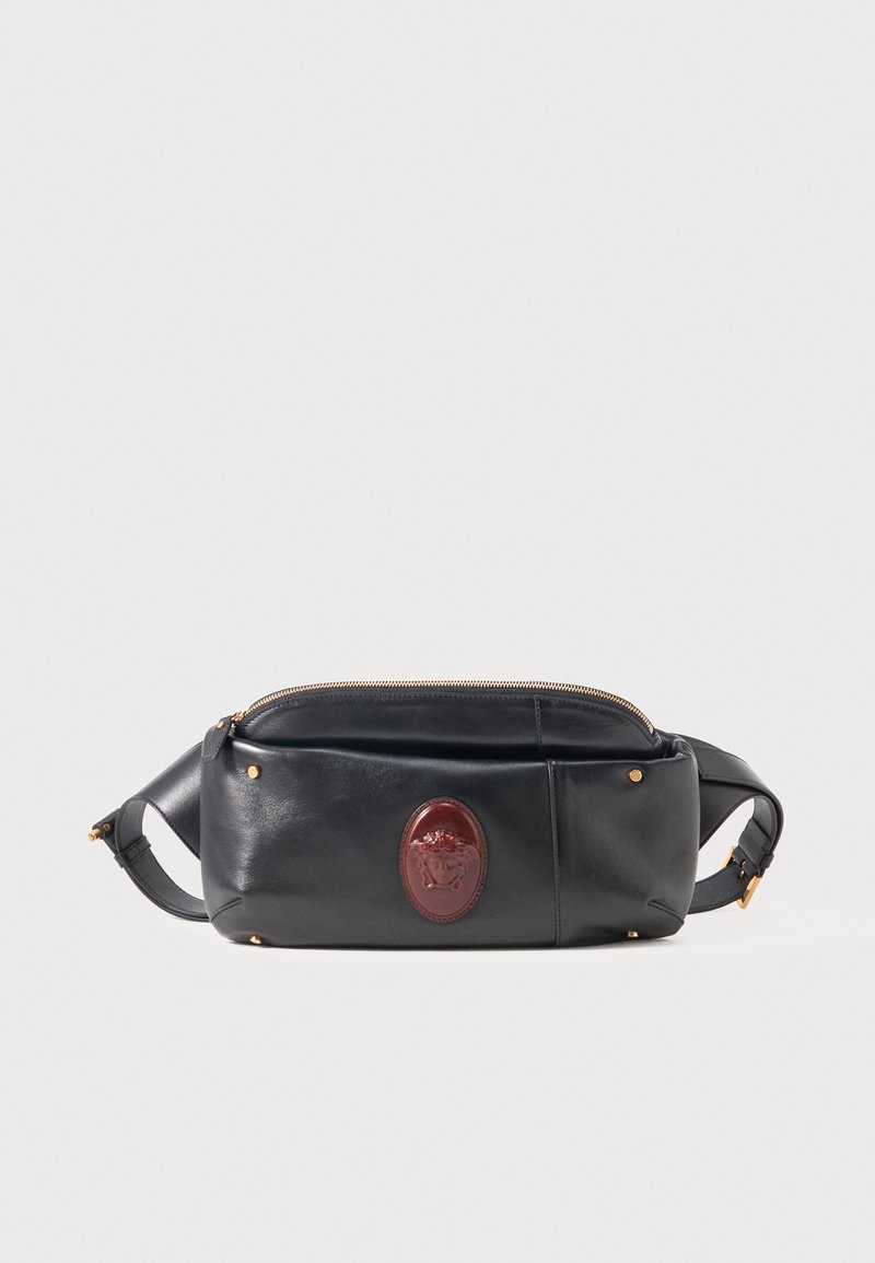 Μαύρο δερμάτινο τσαντάκι μέσης με χρυσά τρουκ και καφέ οβάλ σήμα, με ρυθμιζόμενο λουρί και επάνω φερμουάρ.