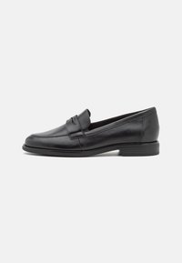 Mocasines de cuero negro con un acabado suave, puntera redondeada y detalles de costura. Tacón bajo apilado y diseño minimalista.
