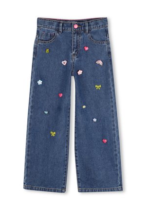 Blauwe spijkerbroek met wijde pijpen, versierd met geborduurde kleine kleurrijke patchwork, inclusief hartjes, bloemen, strikken en een regenboog.