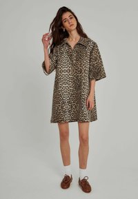 Leopardenmuster Hemdkleid, kurze Ärmel, lockere Passform, Kragen, aus weichem Stoff, mit einem hellbraunen und dunkelbraunen Farbschema.