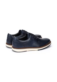 Scarpe in pelle blu navy con una texture liscia, punta rotonda e suola in gomma bianca con accenti marroni. Include chiusura classica con lacci.