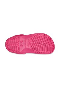 Dno różowych klapek Crocs, z teksturowaną gumową podeszwą z głębokimi bieżnikami, logo marki oraz oznaczeniami rozmiaru. Gładki materiał z zaokrąglonymi krawędziami.