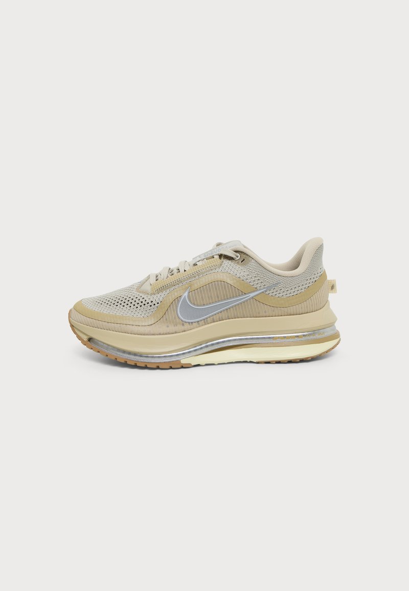 Μπεζ και ανοιχτό καφέ αθλητικό παπούτσι Nike με επάνω μέρος από δίχτυ και ύφασμα, ασημί λογότυπο Swoosh, επενδεδυμένη σόλα και ελαστική εξωτερική σόλα, εμφανίζεται από το πλάι.