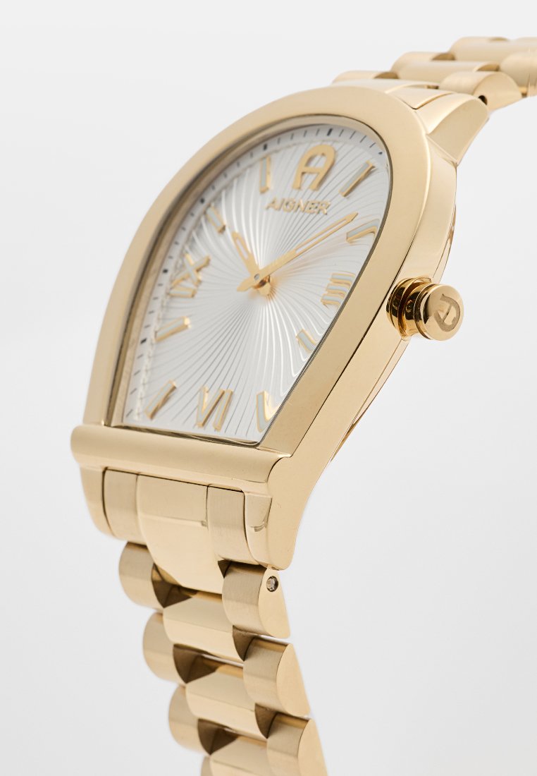 Goldfarbene Uhr mit geschwungenem Gehäuse, silbernem Sonnenschliff-Zifferblatt, goldenen römischen Ziffern und einem Metallarmband mit polierter Oberfläche.