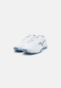 White athletic shoes featuring a mesh upper, light blue accents, textured sole, and a curved design with branded logo on the side.