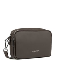 Borsa a tracolla rettangolare in pelle marrone con zip argentata, tracolla regolabile e logo in rilievo sul davanti. Texture liscia, design minimale.