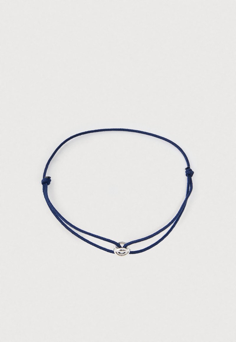 Regulējams tumši zils aukliņu aproce ar mazu sudraba ovālu sprādzi uz baltā fona.