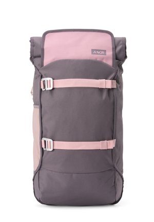 Grau-rosa Rolltop-Rucksack mit zwei rosa horizontalen Gurten und silbernen Schnallen an der Vorderseite, Markenzeichen auf der oberen Klappe sichtbar.