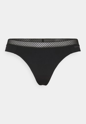 Schwarze Tanga-Unterwäsche mit einem gestreiften, gemusterten Bund, aus weichem Stoff. Verfügt über ein minimalistisches Design und ein Logo an der Seite.