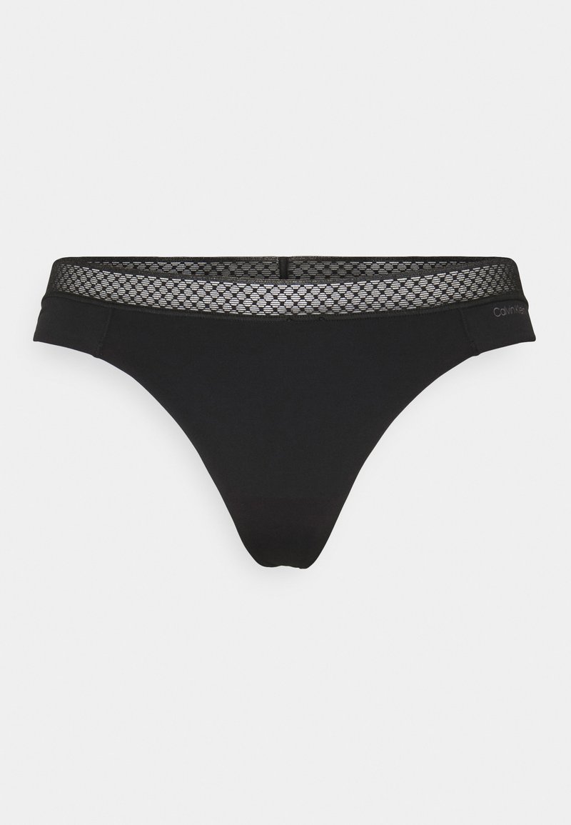 Black thong underwear with a mesh patterned waistband, made from soft fabric. Features a minimal design and a logo on the side.