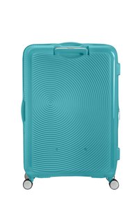 Valise rigide teal avec motif de cercles concentriques, roues doubles, poignée intégrée et fermeture éclair. Texture de surface lisse.