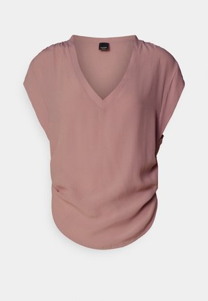 Short-sleeve, V-neck blouse in soft, light pink fabric with a relaxed fit. Features gentle gathering at the shoulder and smooth texture.