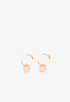 Pendientes de aro de oro con un charm en forma de corazón pulido colgando de cada uno, con texto grabado. Diseño sencillo con un acabado suave.