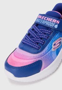 Sneaker impermeabile Skechers blu e rosa con lacci, cinturino in Velcro e suola bianca, che mostra dettagli frontali e laterali.